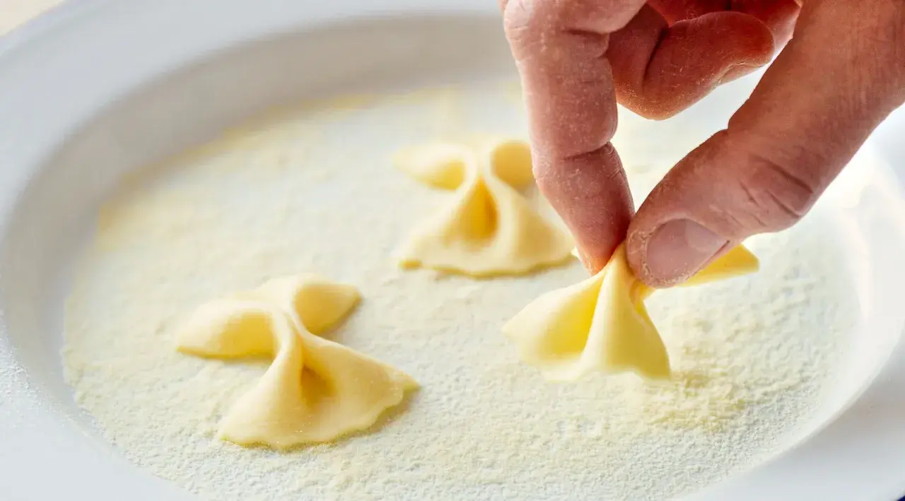Hand formt Farfalle-Nudeln in feinem Grieß, einer semola Alternative.