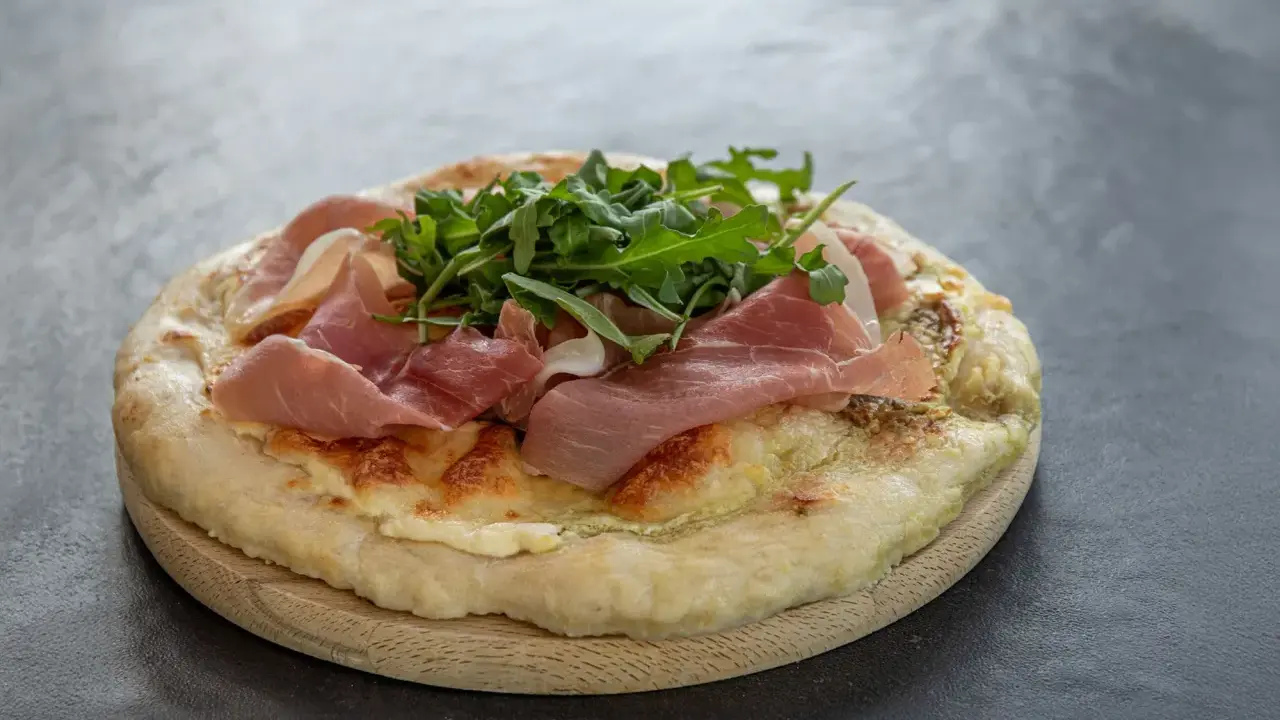 Fladenbrot mit Käse, Rucola und zartem **prosciutto schinken**.
