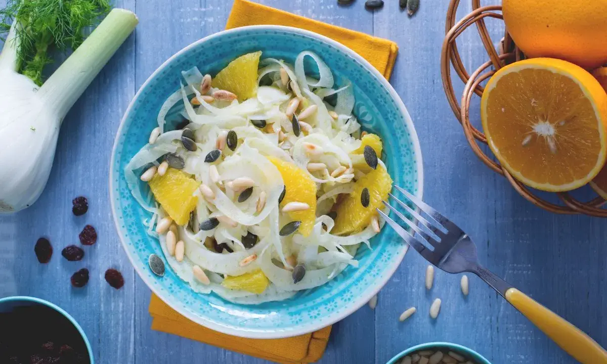 Erfrischender Fenchel-Orangen-Salat mit Pinienkernen und Kürbiskernen, garniert mit frischen Orangen und Fenchel.