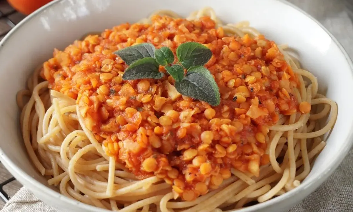 Herzhafte Linsen Bolognese auf Spaghetti, garniert mit frischen Kräutern. Ein köstliches, vegetarisches Gericht.