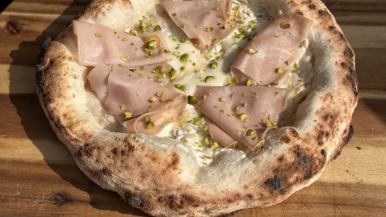 Neapolitanische Pizza selber machen: Ein Genuss mit Mortadella, Pistazien und cremiger Käseschicht.