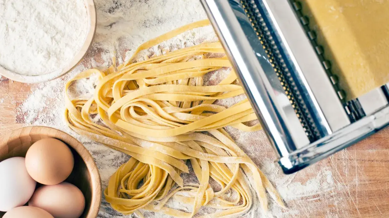Frische Pasta-Rezepte: Teig aus Mehl, Eiern und einer Nudelmaschine für hausgemachte Tagliatelle.