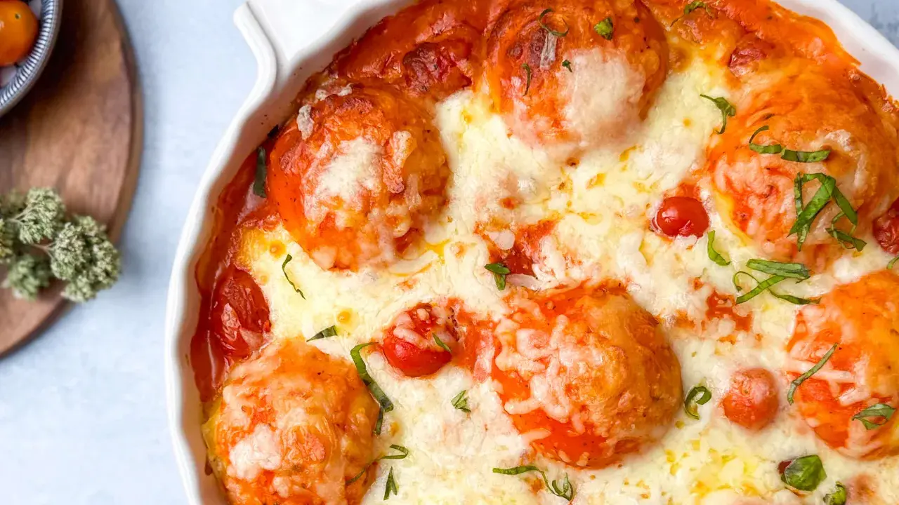 Ein köstlicher Tomate Mozzarella Auflauf mit geschmolzenem Käse und frischen Kräutern, bereit zum Genießen.