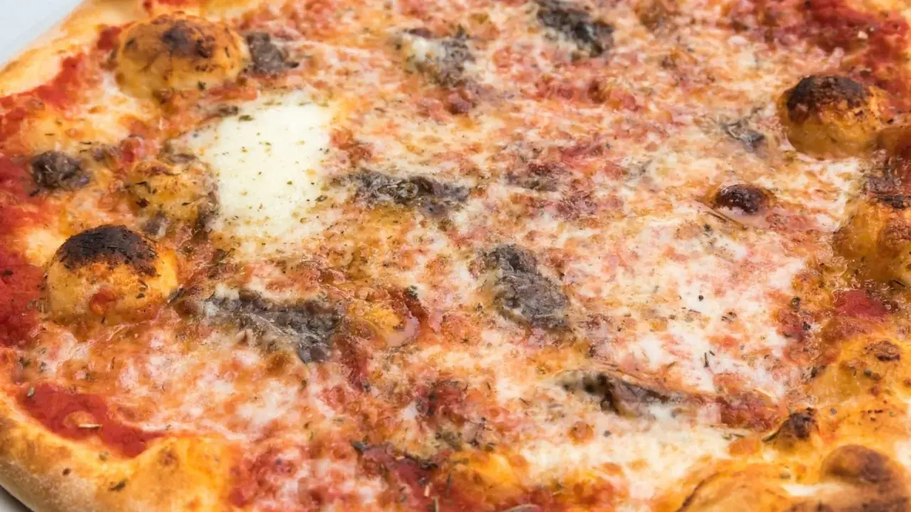 Eine knusprige Pizza Romana mit geschmolzenem Käse, Tomatensauce und dunklen, würzigen Belägen. Was ist drauf?