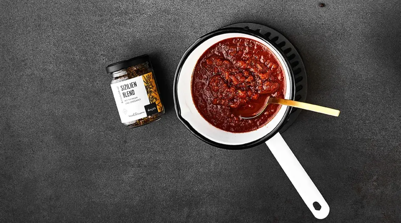 Ein Topf mit köstlichem Sugo di Pomodoro, daneben ein Glas "Sizilien Blend" Gewürzmischung. Perfekt für Pasta!