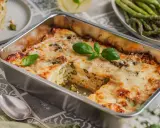 Herzhafte Spargel Lasagne mit geschmolzenem Käse, garniert mit frischem Basilikum. Ein Genuss für jeden Gaumen.