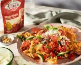 Pasta mit Tomaten, Zucchini und Pinienkernen, bestreut mit Grana Padano. Diese Parmesan-Sorten verfeinern jedes Gericht.