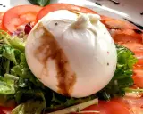 Cremige Burrata auf Tomaten und Salat, ein einfaches Gericht, das sich perfekt für Burrata Rezepte eignet.