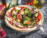 Eine bunte Pizza Veggie mit viel Gemüse wie Brokkoli, Paprika, Auberginen und Oliven.