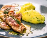 Saltimbocca alla Romana: zarte Kalbsschnitzel mit Salbei und Schinken in einer köstlichen Sauce, serviert mit cremigem Kartoffelpüree.