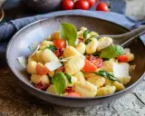 Ein köstlicher Gnocchi Salat mit Kirschtomaten, getrockneten Tomaten, frischem Basilikum und Parmesan.