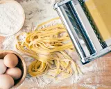 Frische Pasta-Rezepte: Teig aus Mehl, Eiern und einer Nudelmaschine für hausgemachte Tagliatelle.