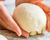 Hände formen einen Teigball, bereit zum stretch and fold pizza.