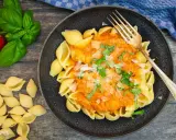 Herzhafte Muschelnudeln mit cremiger Tomaten-Sahne-Sauce, garniert mit frischem Basilikum und Parmesan. Ein Genuss!