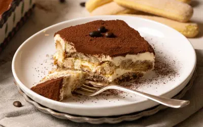 Ein Stück Tiramisu, perfekt für Ihr nächstes tiramisu rezept. Mit Löffelbiskuit, Creme und Kakao bestäubt.