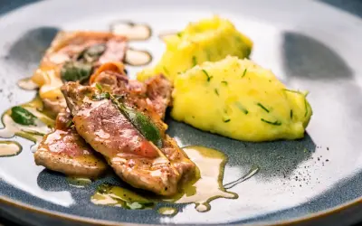 Saltimbocca alla Romana: zarte Kalbsschnitzel mit Salbei und Schinken in einer köstlichen Sauce, serviert mit cremigem Kartoffelpüree.