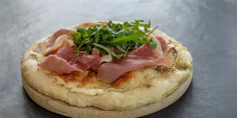 Fladenbrot mit Käse, Rucola und zartem **prosciutto schinken**.