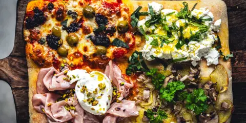 Vier verschiedene Beläge auf einer rechteckigen Pizza in Teglia: Oliven & Tomaten, Ricotta & Kräuter, Mortadella & Burrata, Kartoffeln & Pilze.