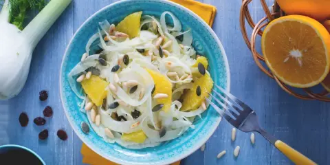 Erfrischender Fenchel-Orangen-Salat mit Pinienkernen und Kürbiskernen, garniert mit frischen Orangen und Fenchel.