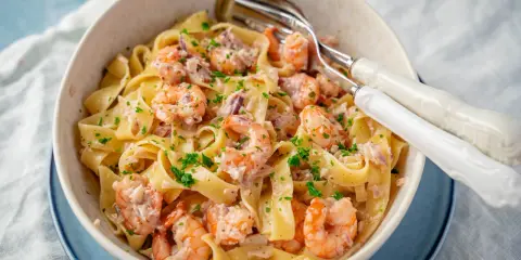 Breite Bandnudeln mit saftigen Garnelen in cremiger Sauce, garniert mit frischer Petersilie. Ein köstliches Gericht mit Spaghetti und Garnelen.