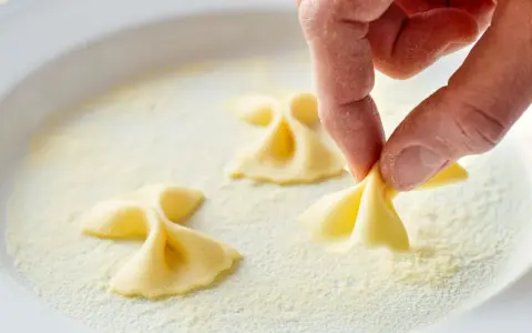 Hand formt Farfalle-Nudeln in feinem Grieß, einer semola Alternative.