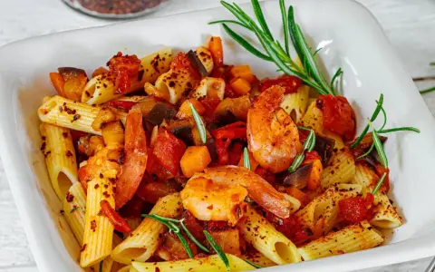 Herzhafte Penne mit saftigen Garnelen, mediterranem Gemüse und frischem Rosmarin. Ein Genuss für alle Sinne!