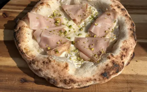 Pizza mit Mortadella und Pistazien auf luftigem pizzateig mit trockenhefe.