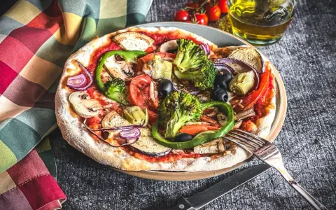 Eine bunte Pizza Veggie mit viel Gemüse wie Brokkoli, Paprika, Auberginen und Oliven.