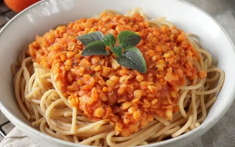 Herzhafte Linsen Bolognese auf Spaghetti, garniert mit frischen Kräutern. Ein köstliches, vegetarisches Gericht.