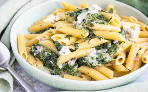 Penne-Nudeln mit cremiger Spinat-Gorgonzola-Sauce und zerbröckeltem Gorgonzola.