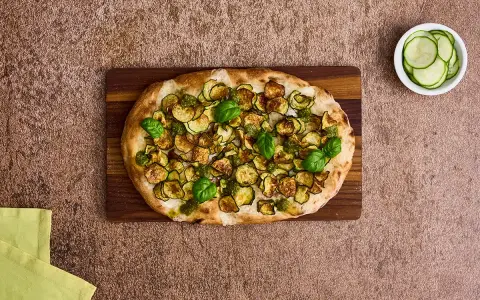 Pinsa mit Zucchini und Basilikum, ein kulinarisches Erbe, das an die Pinsa Herkunft erinnert.