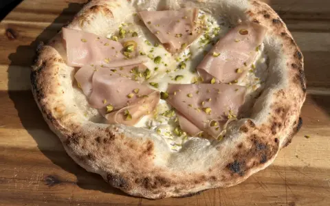 Neapolitanische Pizza selber machen: Ein Genuss mit Mortadella, Pistazien und cremiger Käseschicht.
