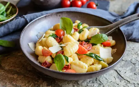 Ein köstlicher Gnocchi Salat mit Kirschtomaten, getrockneten Tomaten, frischem Basilikum und Parmesan.