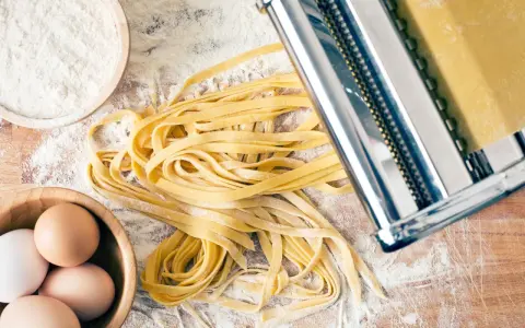 Frische Pasta-Rezepte: Teig aus Mehl, Eiern und einer Nudelmaschine für hausgemachte Tagliatelle.