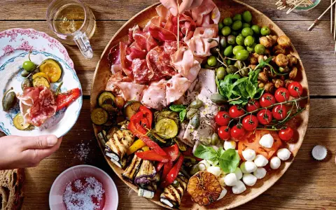 Eine reichhaltige antipasti platte mit Wurst, Käse, Oliven, gegrilltem Gemüse und Tomaten. Perfekt für einen geselligen Abend.