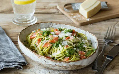 Spaghetti mit frischem Sauerampfer Pesto, Tomatenstücken und geriebenem Parmesan. Ein erfrischendes Gericht, das Lust auf mehr macht.