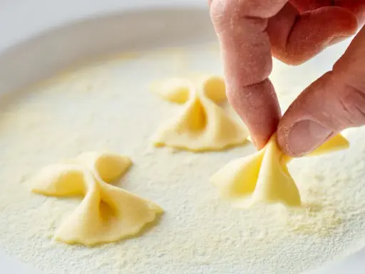 Hand formt Farfalle-Nudeln in feinem Grieß, einer semola Alternative.