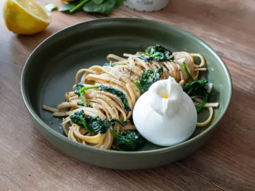 Pasta al limone mit Spinat und cremiger Burrata. Ein Hauch Zitrone und frischer Spinat treffen auf zarte Pasta und eine Kugel Burrata.