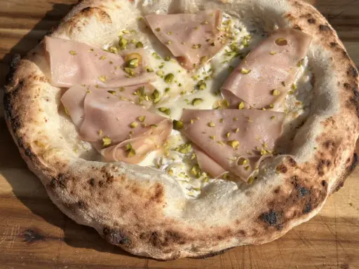 Pizza mit Mortadella und Pistazien auf luftigem pizzateig mit trockenhefe.