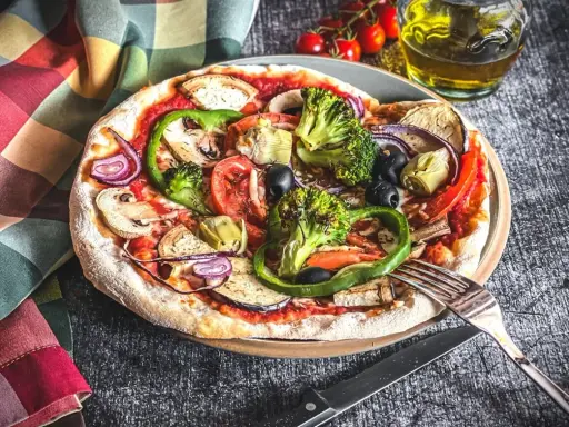 Eine bunte Pizza Veggie mit viel Gemüse wie Brokkoli, Paprika, Auberginen und Oliven.