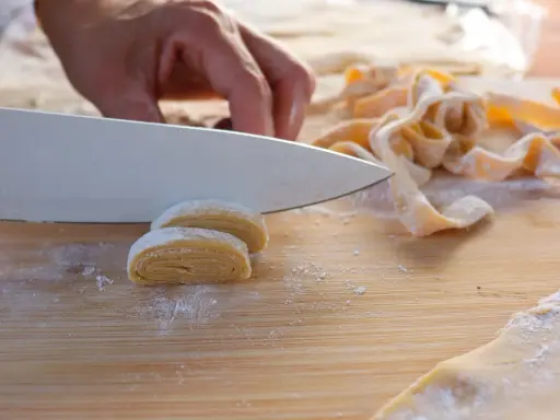 Frische Pasta wird mit einem Messer geschnitten. Der Teig muss ruhen, bevor er weiterverarbeitet wird.
