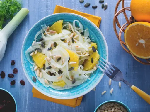 Erfrischender Fenchel-Orangen-Salat mit Pinienkernen und Kürbiskernen, garniert mit frischen Orangen und Fenchel.