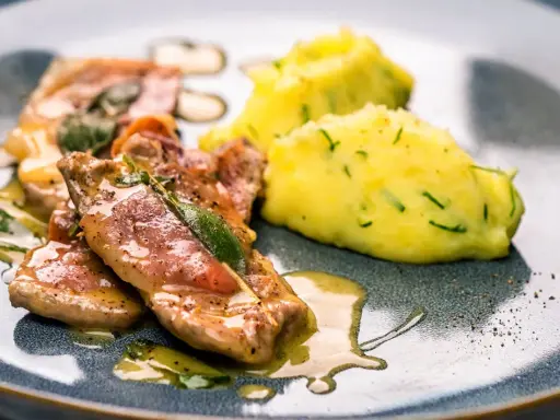 Saltimbocca alla Romana: zarte Kalbsschnitzel mit Salbei und Schinken in einer köstlichen Sauce, serviert mit cremigem Kartoffelpüree.