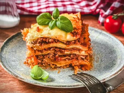 Ein köstliches Stück Lasagne, perfekt geschichtet und mit frischem Basilikum garniert. Dieses Lasagne Rezept ist ein Genuss!