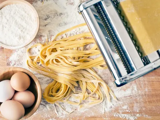 Frische Pasta-Rezepte: Teig aus Mehl, Eiern und einer Nudelmaschine für hausgemachte Tagliatelle.