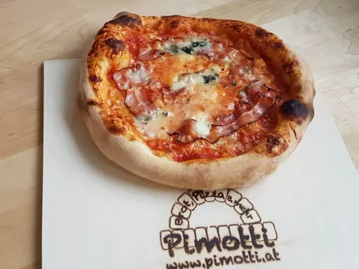 Eine knusprige Pancetta Pizza mit geschmolzenem Käse und Tomatensauce auf einem Holzbrett.