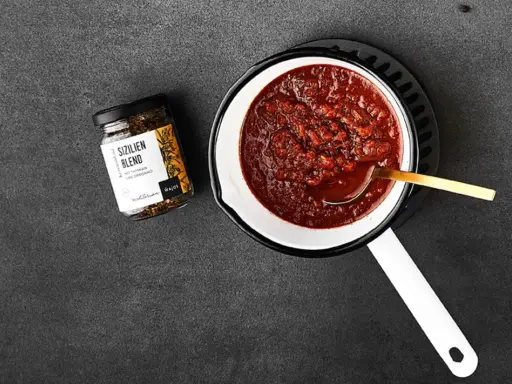 Ein Topf mit köstlichem Sugo di Pomodoro, daneben ein Glas "Sizilien Blend" Gewürzmischung. Perfekt für Pasta!