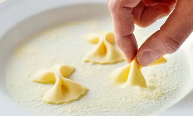 Hand formt Farfalle-Nudeln in feinem Grieß, einer semola Alternative.