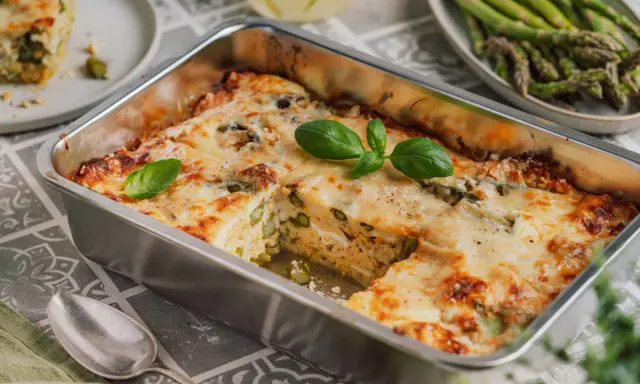 Herzhafte Spargel Lasagne mit geschmolzenem Käse, garniert mit frischem Basilikum. Ein Genuss für jeden Gaumen.