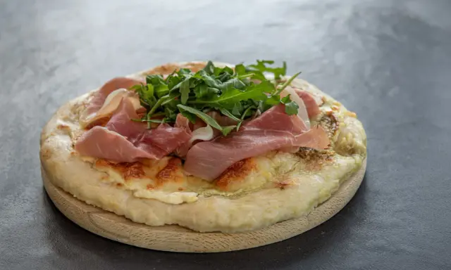 Fladenbrot mit Käse, Rucola und zartem **prosciutto schinken**.